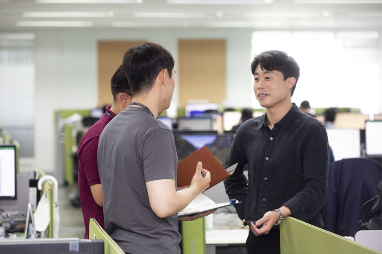 동료와 대화를 나누는 재무 회계 안용수 매니저 사진